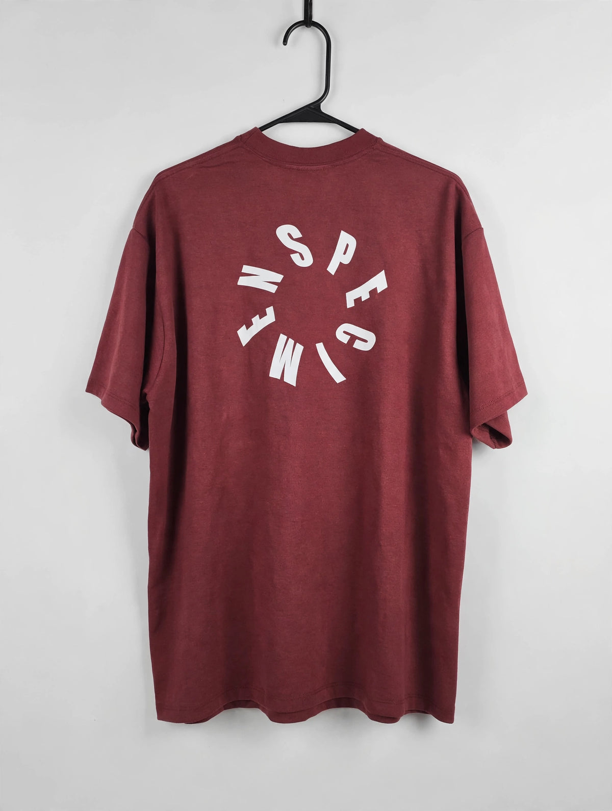 Doers Club red tee back circular graphic on hanger